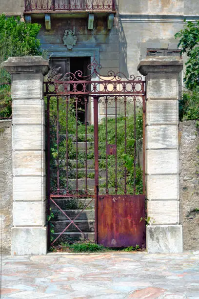 Rusty entrance of a abandoned house with overgrowned stairs