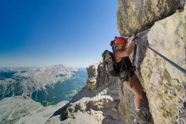 Photo of two women mountain climbers on an exposed Via Ferrata in the Dolomites of Italy