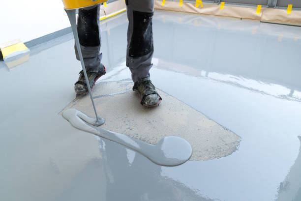 istock construction worker renovates balcony floor and pours watertight resin and glue before chipping and sealing 1174587285