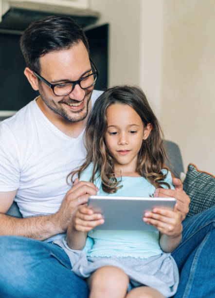 istock Father and daughter looking at digital tablet 1174587712