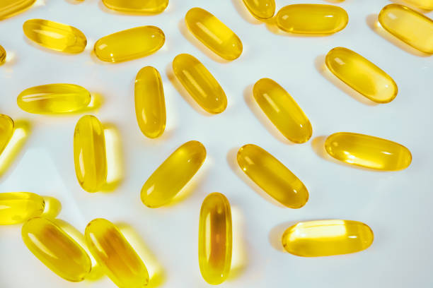fischöl kapseln pillen haufen. medizinischer hintergrund - fish oil cooking oil capsule herbal medicine stock-fotos und bilder