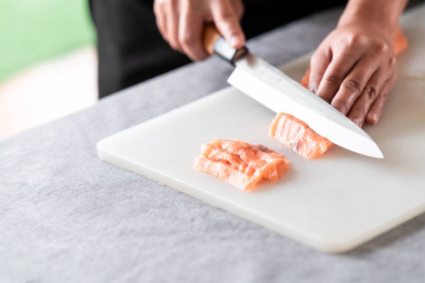 istock Woman chef slicing raw salmon. 1174591027