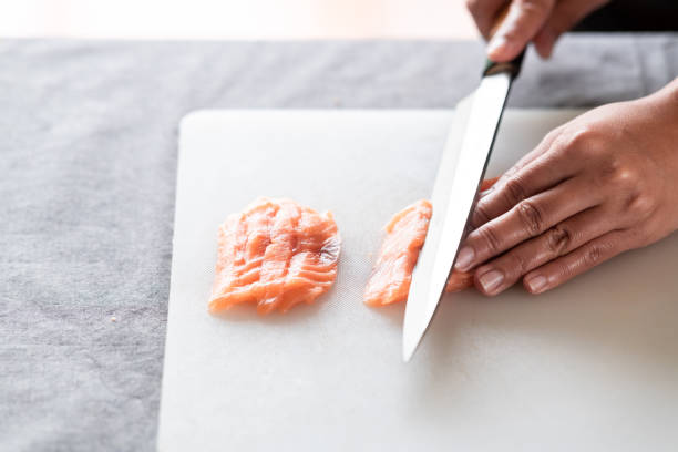 istock Woman chef slicing raw salmon. 1174591051