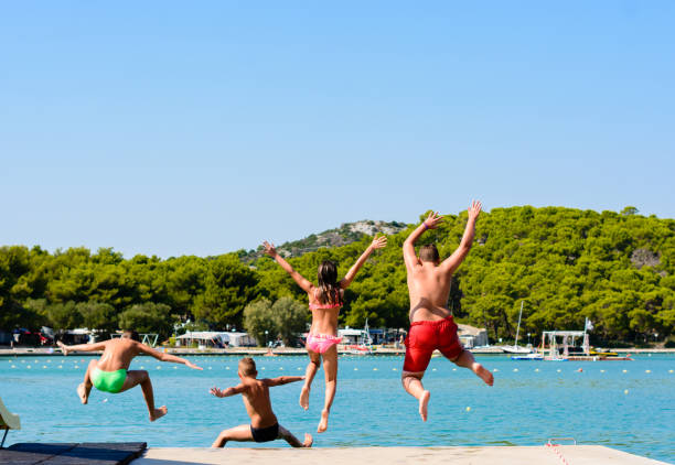 istock Group of children jumping into the sea. 1174593151