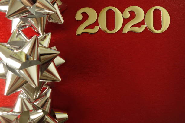 istock Golden number 2020 and silver decorations on red background 1174593968