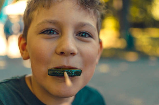 Little Boy Eating Red Lollipop