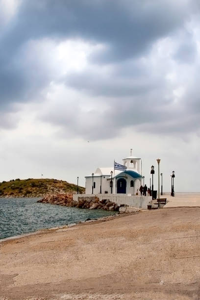 istock Small white chapel  on the coast under a dramatic blue sky in Greece 1174595261