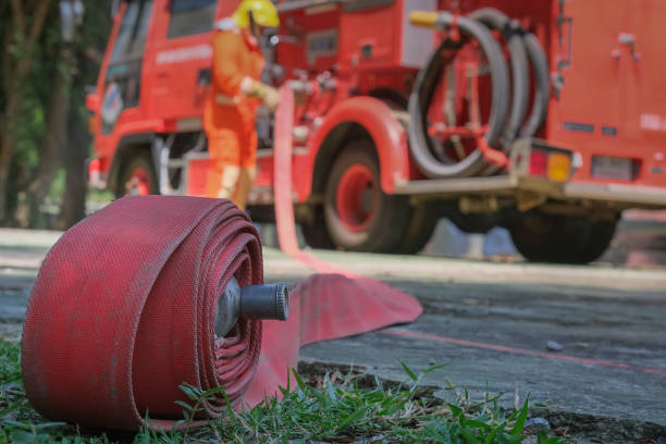 Firefighters training, Team practice to fighting with fire in emergency situation. A fireman carry a water hose run through flame