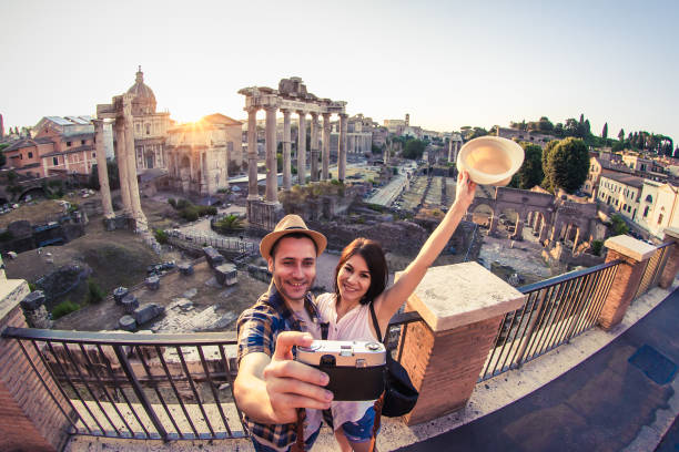 若いカップルの観光客は、日の出にローマフォーラムを見て、自分撮りを取ってキス。イタリア、ローマの歴史的な帝国フォロ・ロマーノ。 - travel tourist roman forum rome ストックフォトと画像