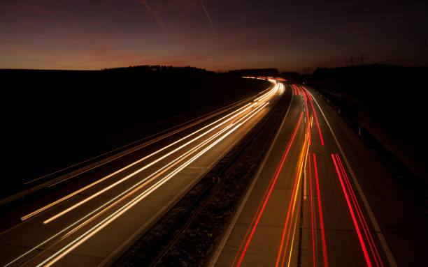 istock Motion blurred car lights at night. Straight and gently curved highway. Sunset. 1174603963