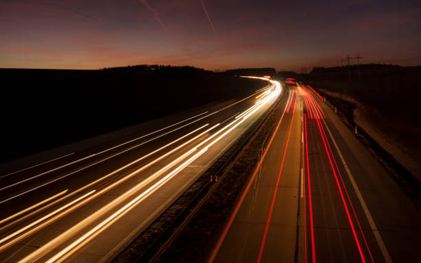 istock Motion blurred car lights at night. Straight and gently curved highway. Sunset. 1174603966