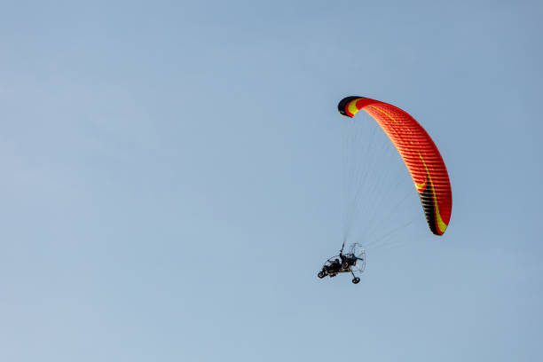 istock bright paraglider with a motor flies in the blue sky 1174604048