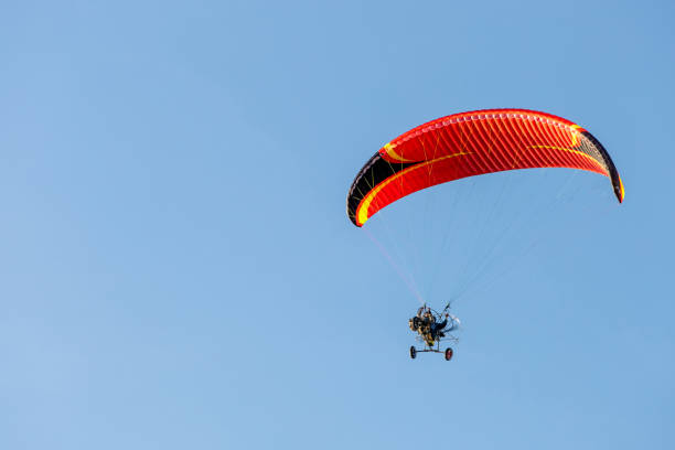 istock bright paraglider with a motor flies in the blue sky 1174604050