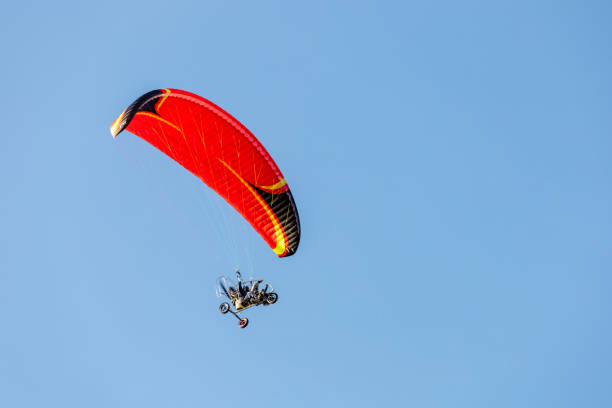 istock bright paraglider with a motor flies in the blue sky 1174604052