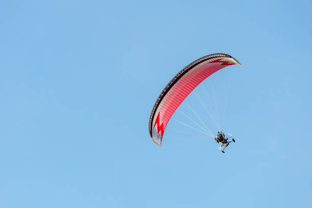 istock bright paraglider with a motor flies in the blue sky 1174604116
