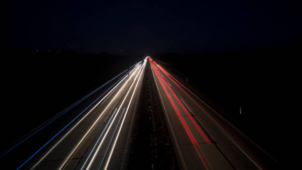 istock Motion blurred car lights at night. Straight and gently curved highway. Sunset. 1174604206
