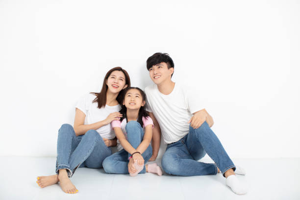 istock Happy Young family Sitting On Floor Looking Up 1174606420