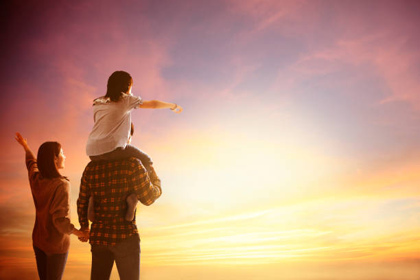 happy family standing and watching the sunset