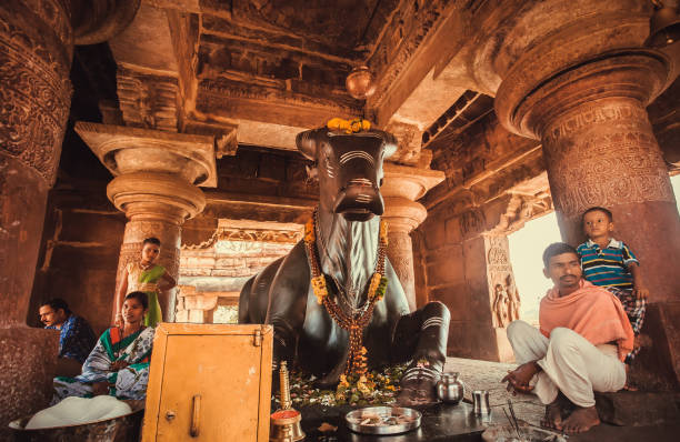 indù seduti vicino al toro nandi dopo il rituale puja nel tempio tradizionale - indian ethnicity traditional culture architecture karnataka foto e immagini stock