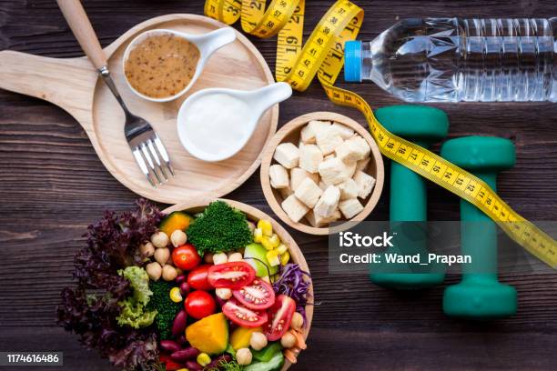 Fresh Vegetable Salad And Healthy Food For Sport Equipment For Women Diet Slimming With Measure Tap For Weight Loss On Wood Background Healthy Sport Concept Stock Photo - Download Image Now