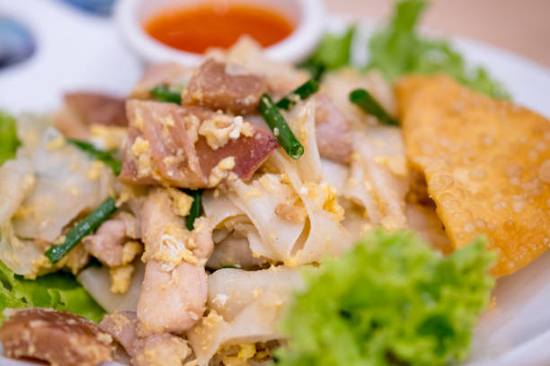 istock Chinese-Thai dish made with stir-fried rice noodles mixed with chicken, egg, squid and lettuce. (Kuaitiao khua kai) 1174616539