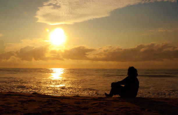 istock Indian woman meditating on morning sunrise beach 1174620231