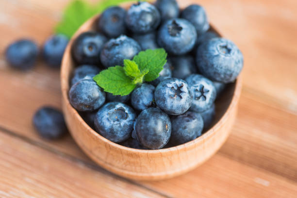 istock Fresh and natural blueberry with mint on a wooden table 1174620333
