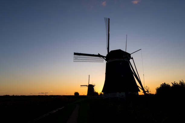 istock Windmills are silhouetted against the evening sky 1174620442