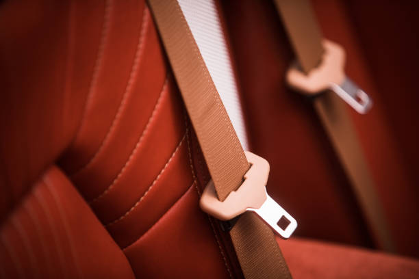 Color close up of a brown seat belt in a modern car.