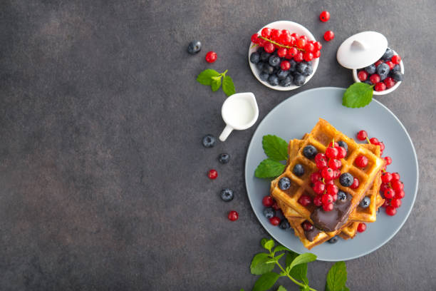 Sweet dessert belgian waffles with chocolate, blueberry and red currant