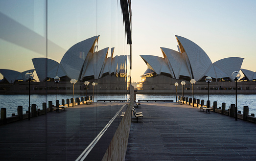 Sydney Australia - August 16, 2018: A bright morning in Sydney, New South Wales, and this is the view looking across Circular Quay towards the iconic shape of the city's Opera House, which is reflected in the windows on the left.