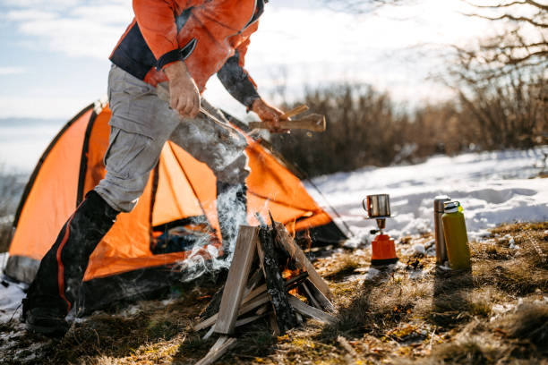 istock Man camping in mountain range on snowy winter day 1174625281