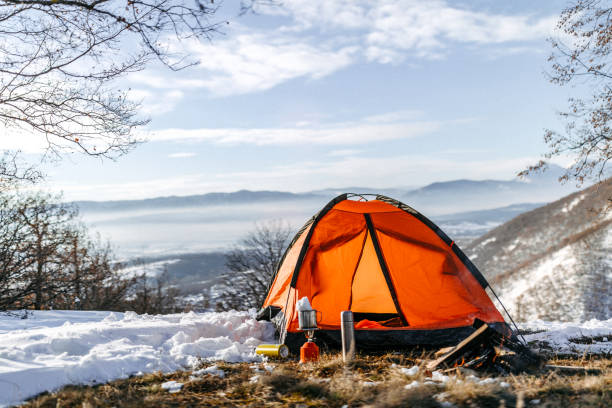 Orange tent in nature, on snowy mountains, no people around
