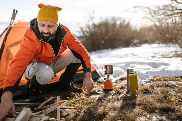 istock Man camping in mountain range on snowy winter day 1174625366
