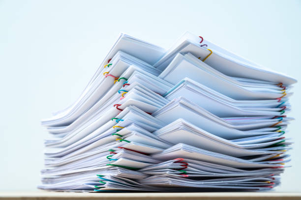 istock Stack of document paper with colorful paperclip place on wooden table. 1174629992