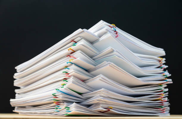 istock Stack of document paper with colorful paperclip place on wooden table. 1174630014