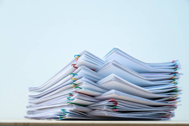 istock Stack of document paper with colorful paperclip place on wooden table. 1174630047