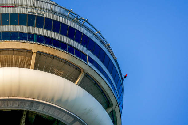 CN Tower, originally Canadian National Tower, is one of Canada's most iconic symbols and defines Toronto's skyline. It is considered as one of the 7 Wonders of the Modern World, and still remains the tallest free-standing structure in the Western Hemisphere till today. A man is pictured here, hands free and on a harness, hanging out on the ledge of the CN Tower as part of the CN Tower Edge Walk.