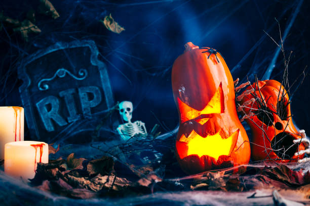 istock Halloween decor, Jack's Lantern band with glowing eyes, mystical glow, spider web,dry leaves, dark background, burning candles, skeleton bones 1174635907