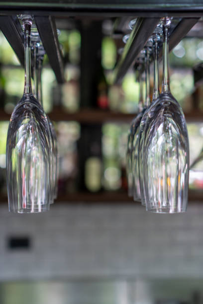 A lot of champagne glass hanging on a rack with blurred background