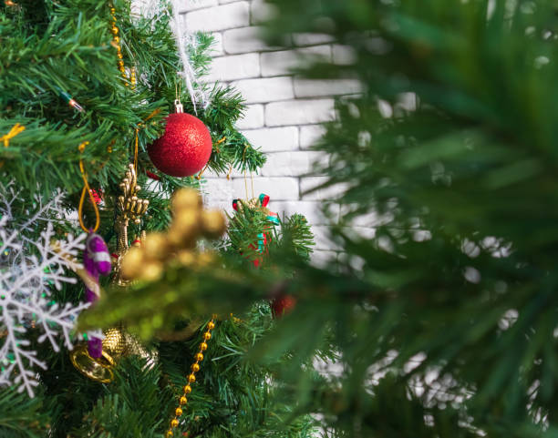istock Christmas tree decorated with Red balls toys on a white wall, copy space. 1174638926