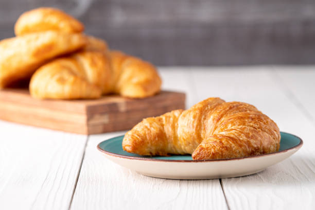 Flacky crispy fresh croissant rolls with blue background stock photo
