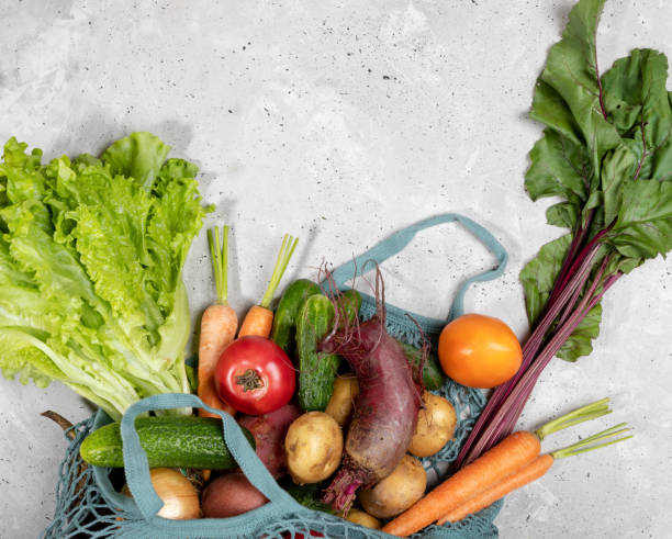 istock Close-up part of string bag with fresh farm vegetables on grey concrete background. 1174643483