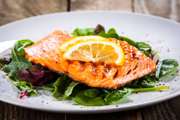 istock Grilled salmon on fresh vegetables on wooden table 1174643595