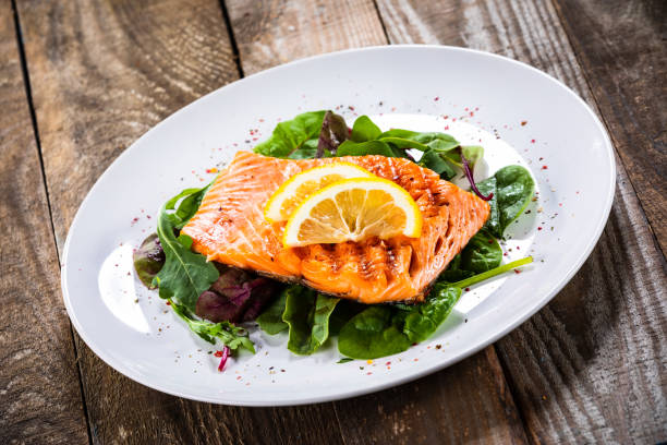 istock Grilled salmon on fresh vegetables on wooden table 1174643634