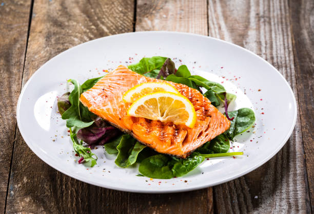 istock Grilled salmon on fresh vegetables on wooden table 1174643673