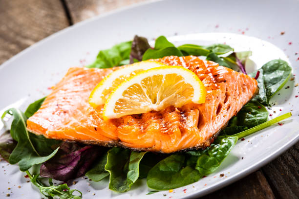 istock Grilled salmon on fresh vegetables on wooden table 1174643722