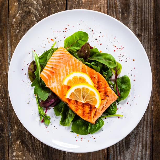 istock Grilled salmon on fresh vegetables on wooden table 1174643732