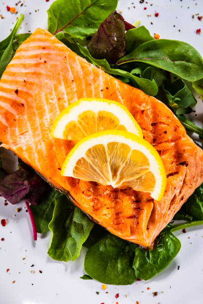 istock Grilled salmon on fresh vegetables on wooden table 1174643916