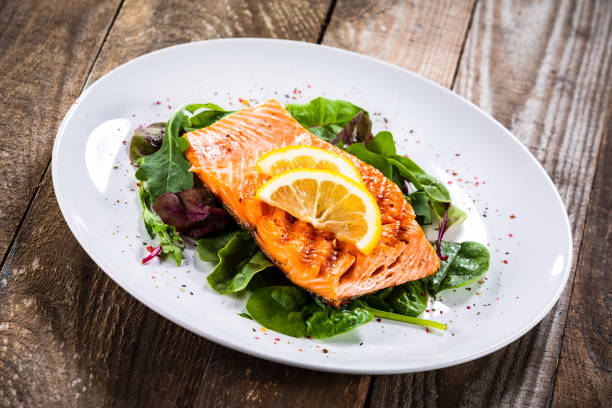 istock Grilled salmon on fresh vegetables on wooden table 1174643979